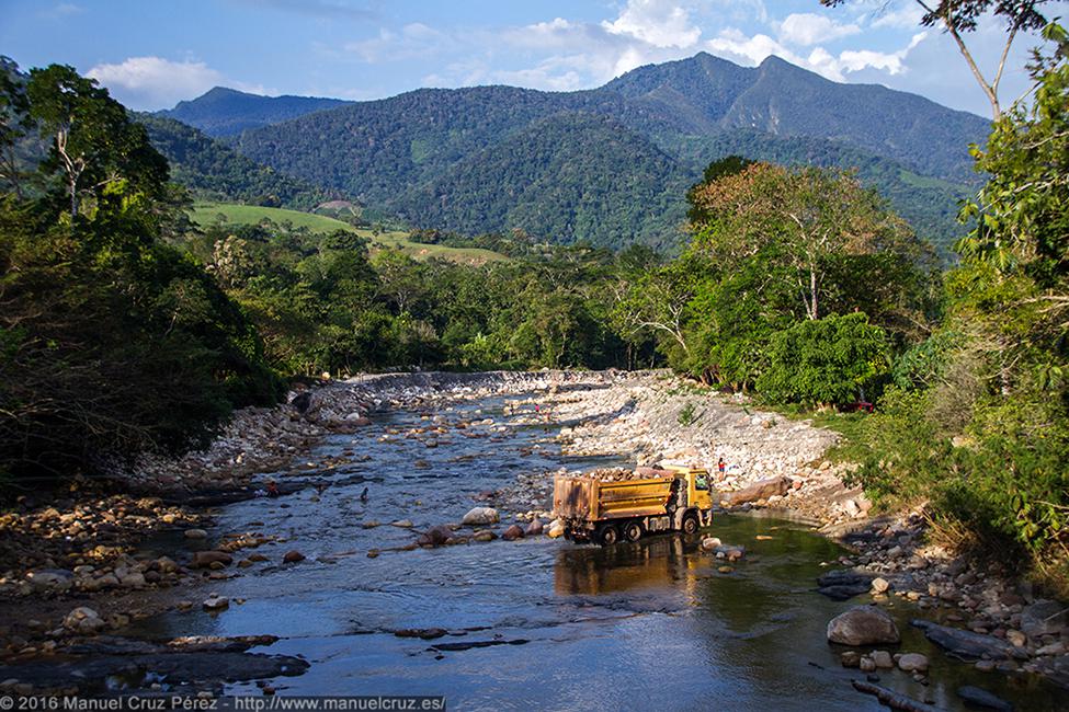 Camión cruzando el río Cumbaza mientras los vecinos se bañan y lavan la ropa.